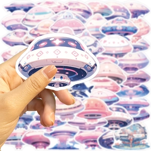 Detailed view of colorful pastel UFO stickers held by hand for laptop and guitar decoration