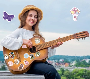Détail d'autocollants de dessins animés colorés avec animaux et fleurs sur une guitare
