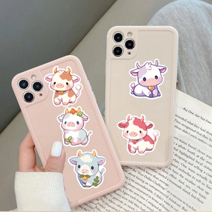 Close-up of cute cartoon cow phone cases in pink and beige with protective camera rings