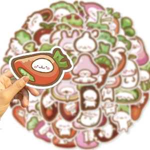 Gros plan d'une main tenant un autocollant carotte d'un lot de stickers de légumes