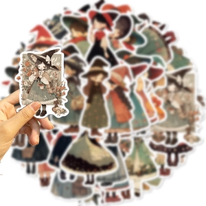 Close-up of a hand holding a cute chibi witch sticker with vintage cartoon colors