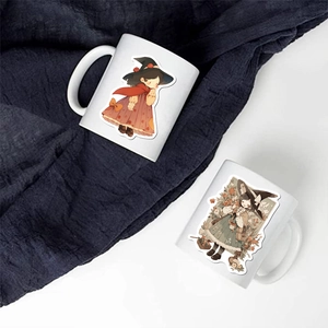 Close-up of two white ceramic mugs featuring cute cartoon witch and forest girl illustrations
