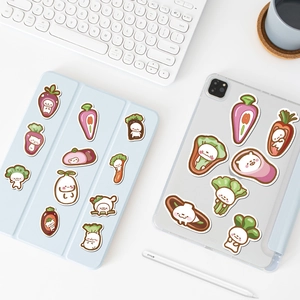 Détail de mignons autocollants chat-légume décorant un étui de tablette bleu et une coque