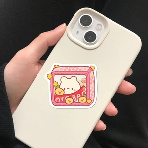 Close-up of matte off-white silicone phone case with cute cartoon bear and strawberry print