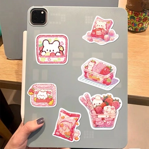 Close-up of cute pink strawberry bear stickers on a grey tablet back, waterproof DIY decals
