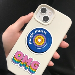 Detail of cream iPhone case with retro magic music and 3D OMG stickers in hand