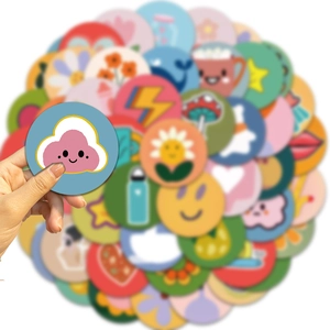 Close-up of a hand holding a colorful sun and cloud sticker from a 50-piece DIY set