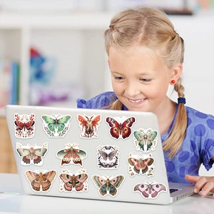 Girl decorating laptop with colorful vintage butterfly and moth waterproof stickers