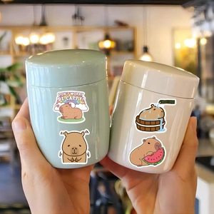 Macro shot of cute capybara stickers on round ceramic jars with creative DIY decorations