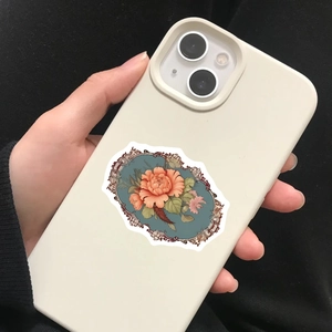 Close-up van vintage bloemensticker met oranje bloem op een beige telefoonhoesje