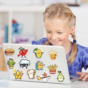 Girl smiling next to laptop decorated with colorful cartoon food and object stickers