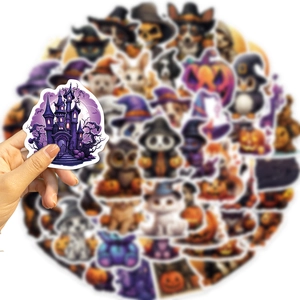 Close-up of a hand holding a Halloween cartoon castle sticker with blurred stickers background
