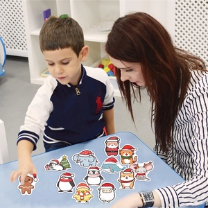 Detailed view of Christmas animal stickers being applied by a child on a blue desk
