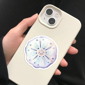 Close-up of cream white phone case with circular sea creature pattern held by hand