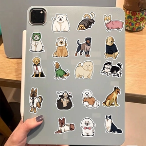 Close-up of cute cartoon dog stickers applied to a gray tablet on a wooden surface
