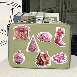 Pink Christmas stickers with gingerbread house and tree patterns shown on a laptop bag