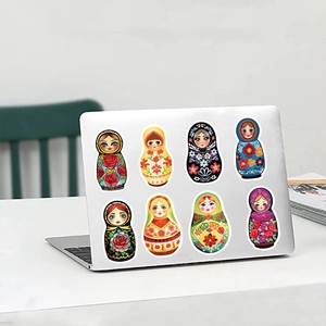 Detailed view of 8 colorful Russian Matryoshka doll stickers on a silver laptop surface