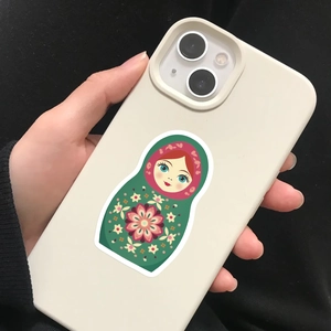 Matryoshka doll graphic on off-white phone case shown as hand-held detail view