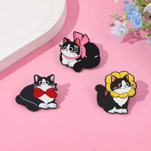 Three cute black and white cartoon cat enamel pins with colorful bows on a pink background