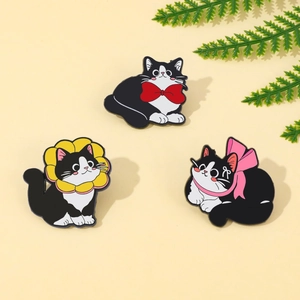 Detailed view of three cute enamel cat pins with red bows and sunflower headbands
