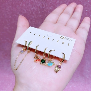 Detail of 6-piece earring set featuring colorful zircons and gold hoops on display card