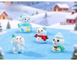 Close-up of four miniature resin snowmen with scarves and hats for winter scene decor