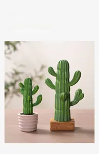 Detail showing two Nordic resin cactus plants in pink and brown pots on wooden table