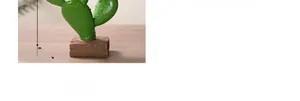 Detailed view of an 8cm green resin cactus figurine on a brown wood-textured base