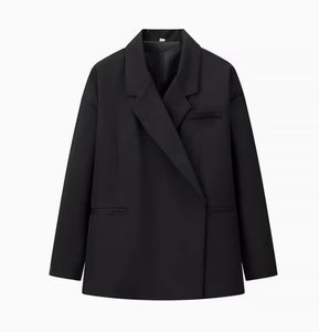 Détail d'un blazer noir surdimensionné avec col à revers et poches à rabat sur fond blanc