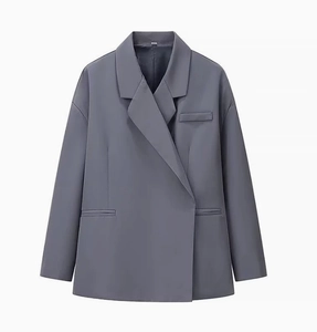 Détail d'un blazer gris foncé pour femme avec revers et bouton latéral