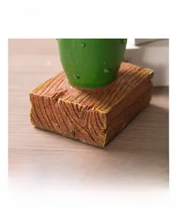 Detail of Nordic resin cactus figurine showing vintage wood grain base and green texture