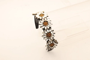 Macro detail of headband featuring crystal daisy flowers with amber centers on black base