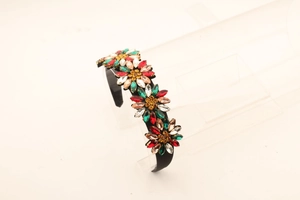 Detail view of sunflower rhinestone headband with colorful crystals on a black band