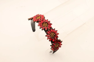 Detailed view of red rhinestone sunflower headband with crystals on acrylic stand