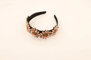 Close-up of sparkling rhinestone sunflower pattern on a wide black fashion headband
