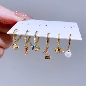 6-piece gold ocean charm hoop earring set featuring shells, seahorses, and blue cubic zirconia