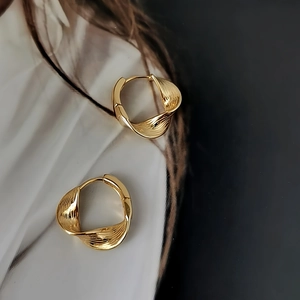 Orecchini in argento S925 con texture a torsione dorata e un elegante design a cerchio