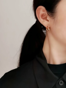 Dettaglio dell'orecchino in argento S925 con trama a spirale in oro rosa su modella
