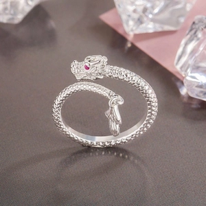 Macro view of dragon ring with silver scales and red gemstone eye on ice cubes
