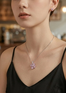 Detalle del collar con colgante de flor de circón rosa y pendientes de corazón