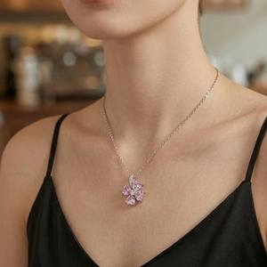 Elegante collar de plata con flor de circón rosa usado en el cuello de una mujer
