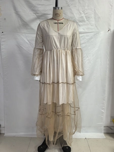 Détail d'une robe beige à col en V avec manches lanternes en mesh et jupe à volants