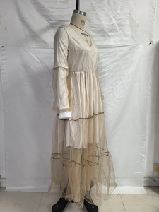 Détail de la robe beige montrant le col en V et la texture des couches de tulle mesh