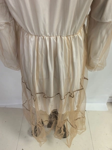 Détail de robe en tulle à col en V avec manches bouffantes et bordure ondulée