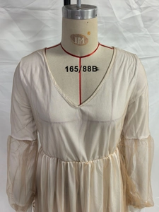 Détail de robe beige à col en V avec manches bouffantes en tulle élégantes sur mannequin