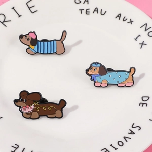 Gros plan détaillé de trois broches en émail teckel sur une assiette décorative en céramique