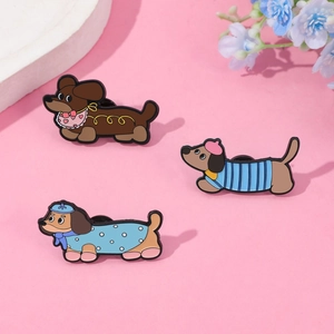 Trois pin's en émail teckel mignons avec des tenues colorées sur fond rose