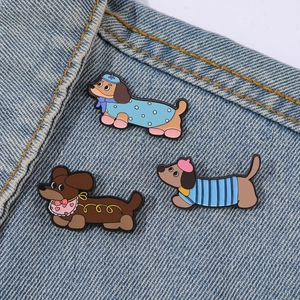 Lot de trois pin's en émail teckel mignon portés sur le col d'une veste en jean
