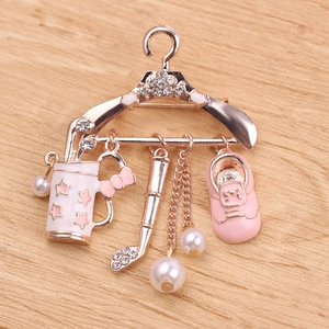 Macro detail of rose gold clothes hanger brooch with pink charms and crystals