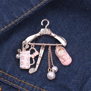Macro detail of rose gold golf themed hanger brooch with enamel charms on denim backdrop